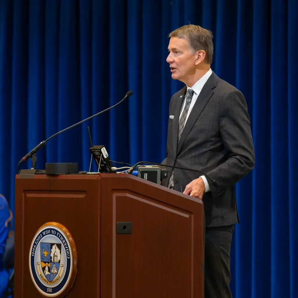 UNE President James Herbert speaks at the podium